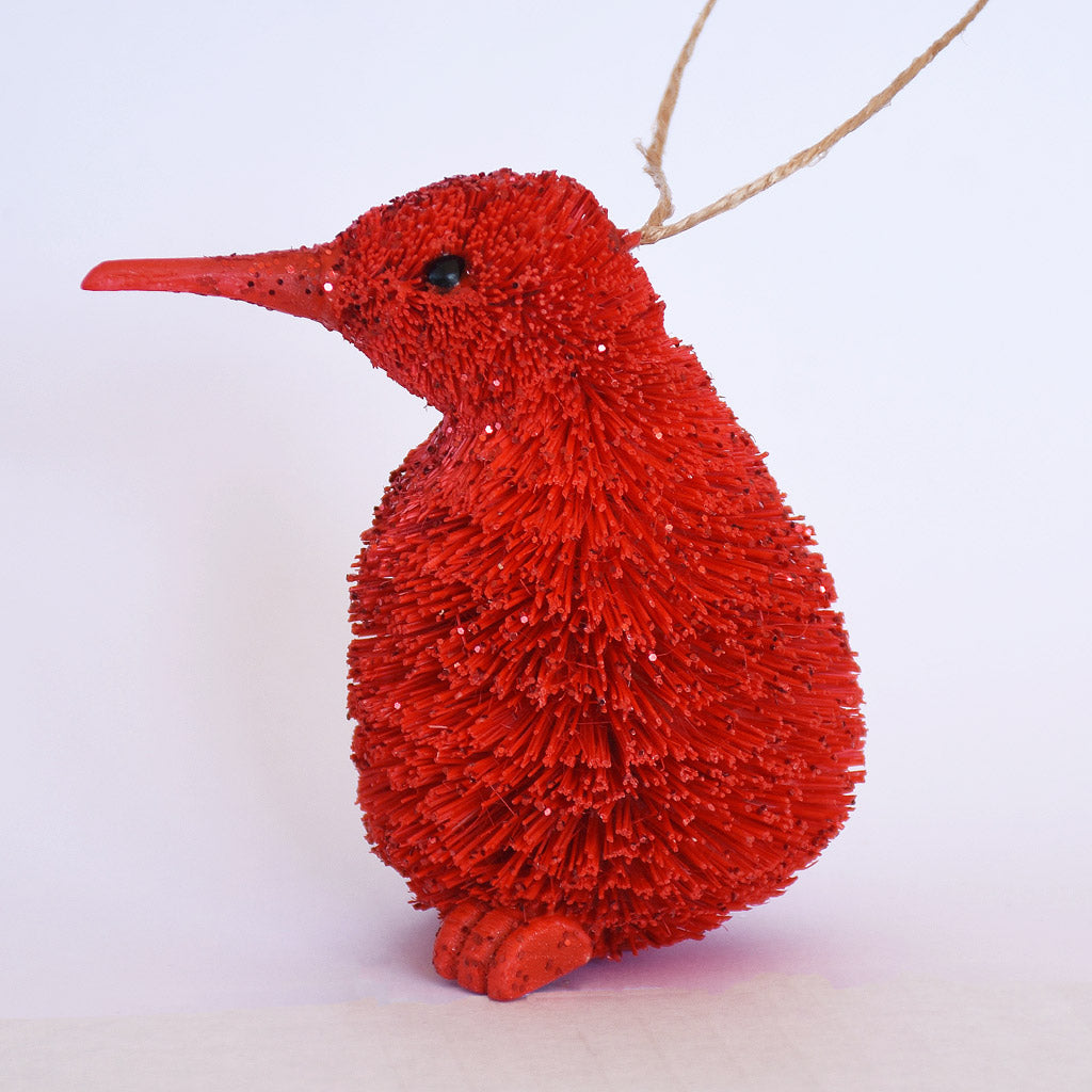 Decorative Bristle Kiwi bird ornament with glittery red finish on a white background