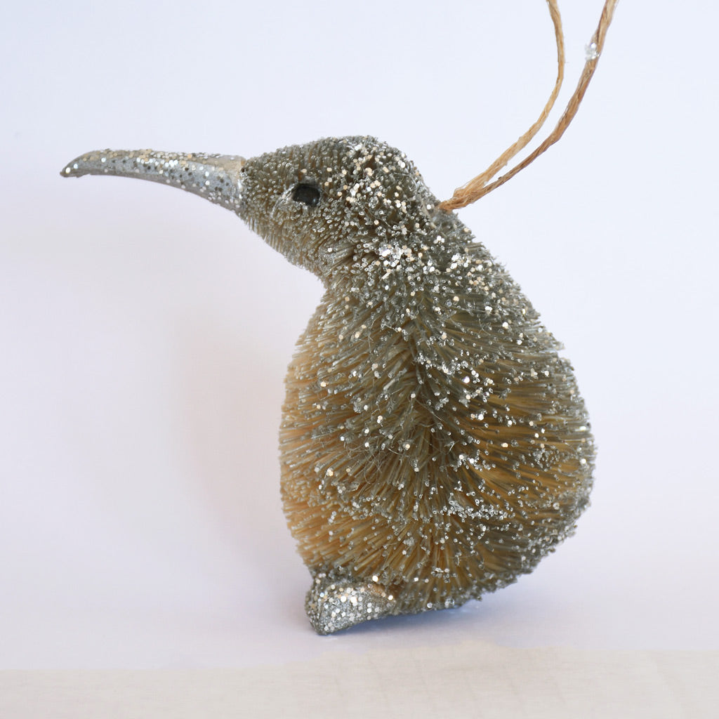 Decorative Bristle Kiwi bird ornament with glittery finish on a white background