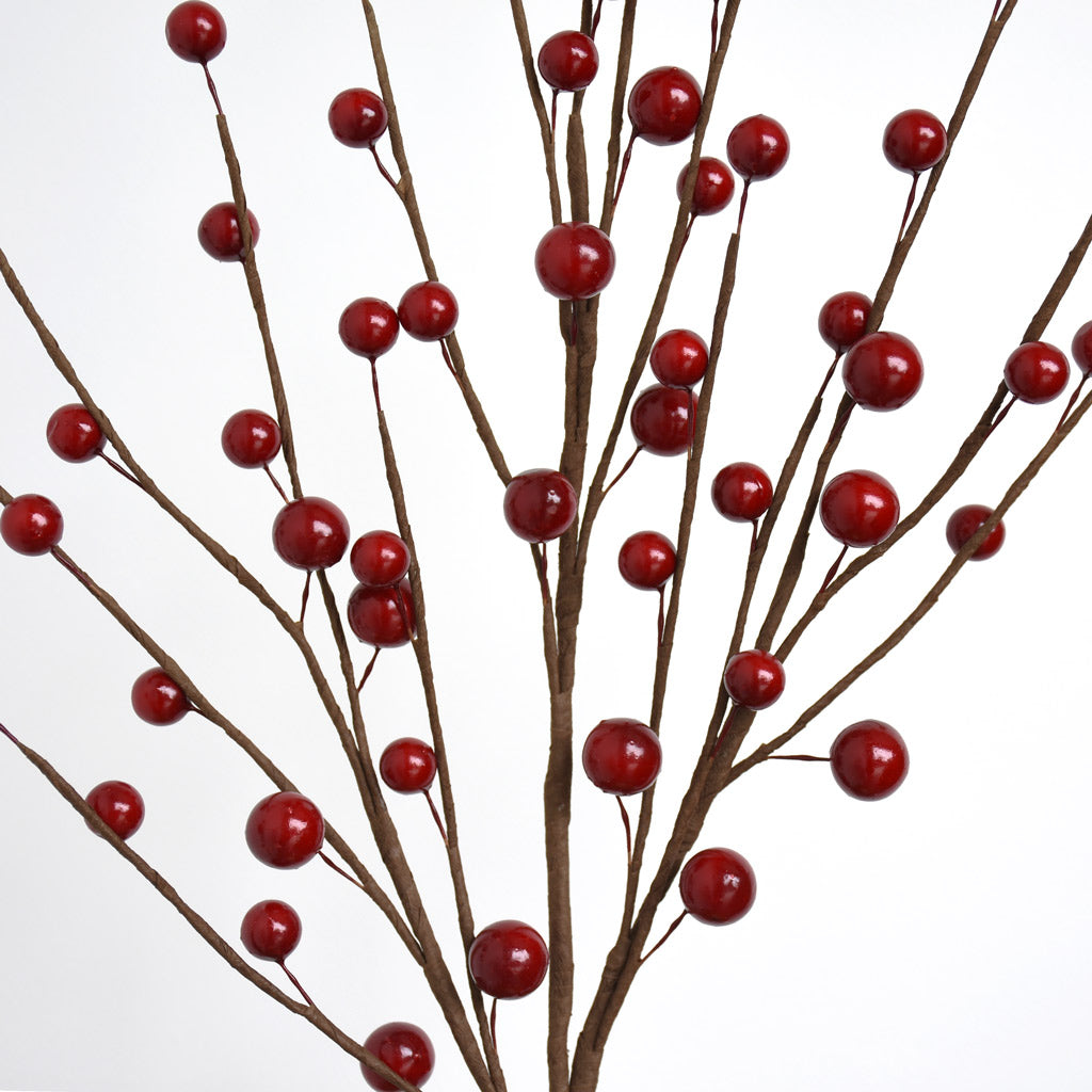 Close-up of artificial red berry branches on a white background